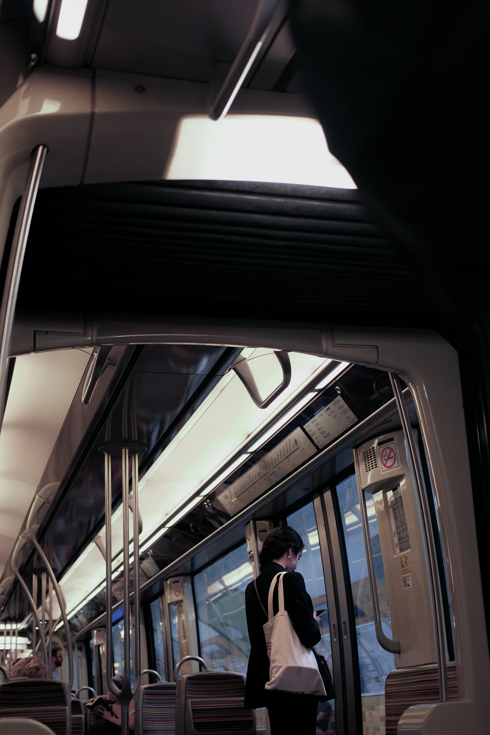 a woman wearing black is standing inside of a train