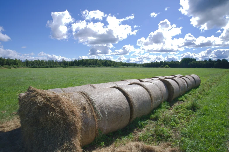 hay bales are stacked in the foreground of a large field