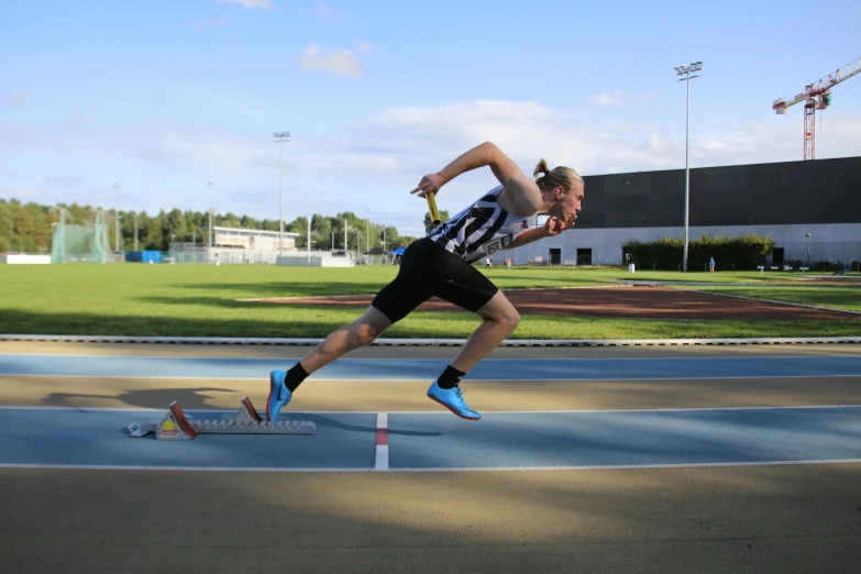 a male athlete jumps his foot to his knees