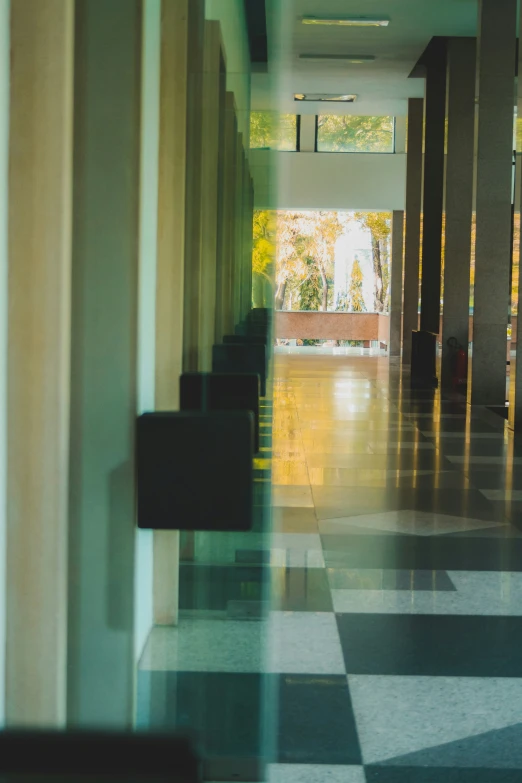 a hallway with several black chairs on a checkered floor