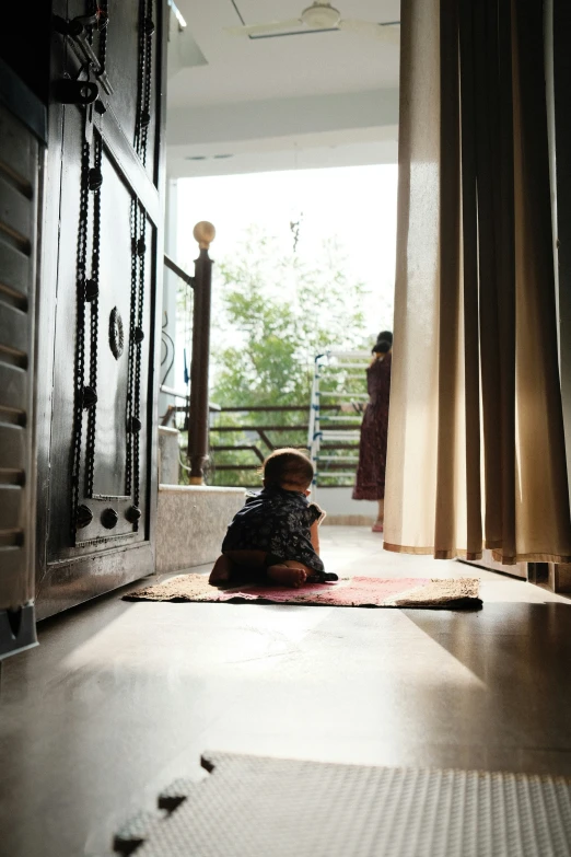 a person stands near a door looking at a bird in front