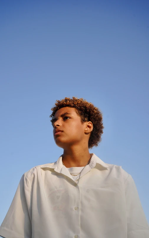 young man looking to the side while wearing a white shirt