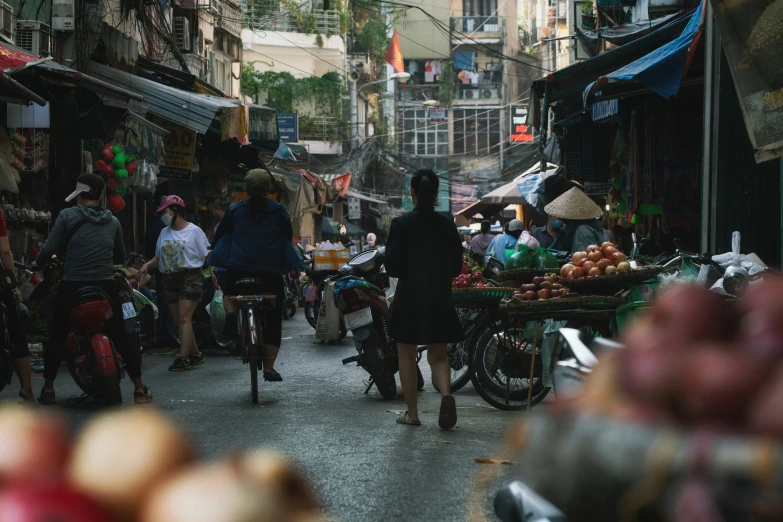 a group of people standing in a market with bicycles