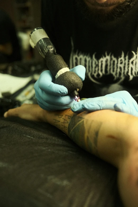 tattoo artist putting ink on someones arm