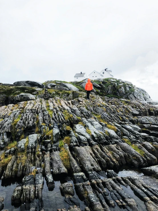 a person walking on rocks at the top of a mountain