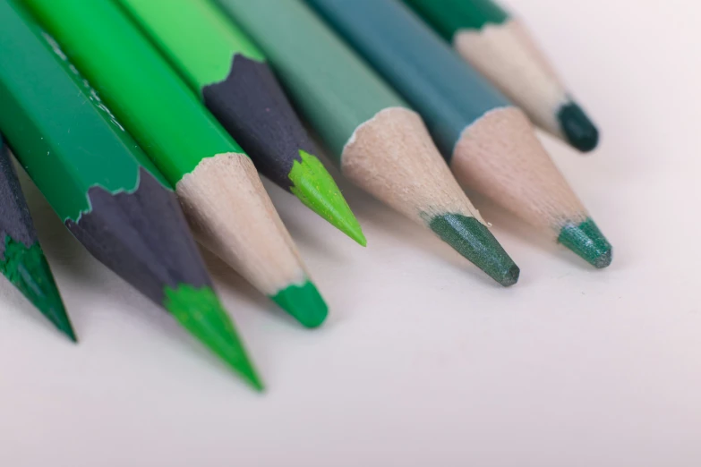 several pencils in the middle one green, one grey