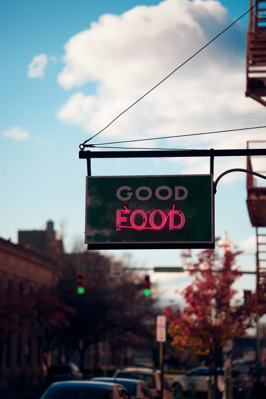 a neon sign on a post on a street corner