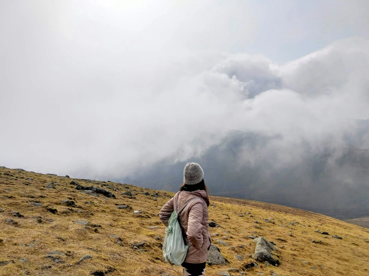 a person is on the top of a hill with a backpack