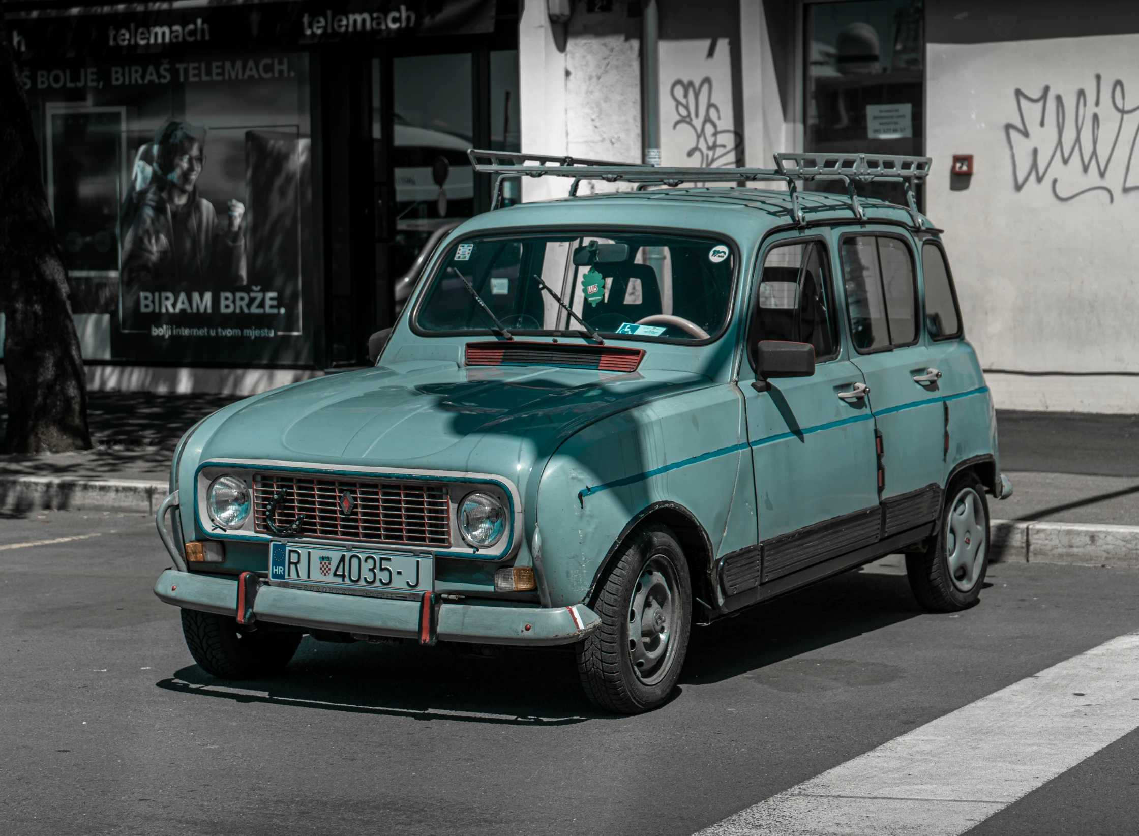 a blue van parked in the street by some stores