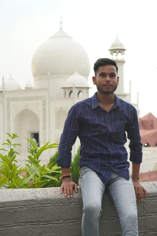 a man is sitting on the ledge with his feet crossed