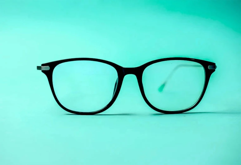 a pair of glasses sitting on a blue background