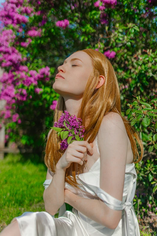 a beautiful red haired woman laying in the grass