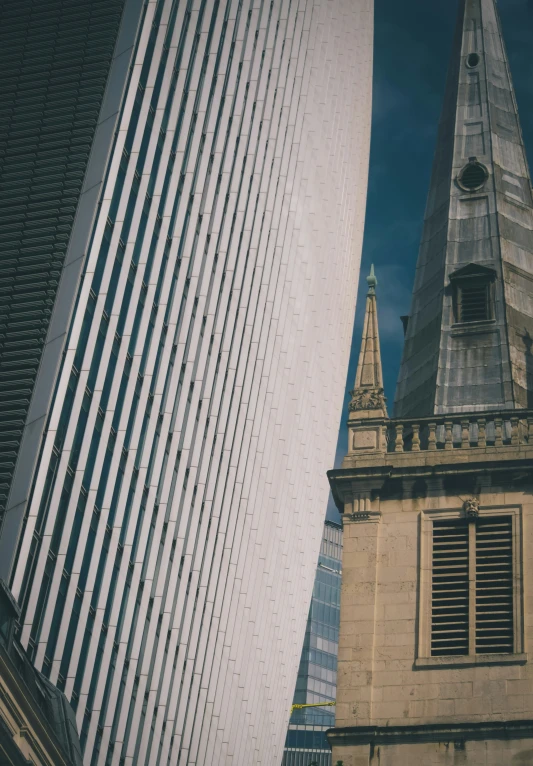 two buildings with windows and a spire behind them