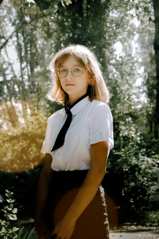 a woman is standing outdoors wearing glasses