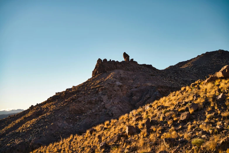 a person standing on top of a hill covered in rocks