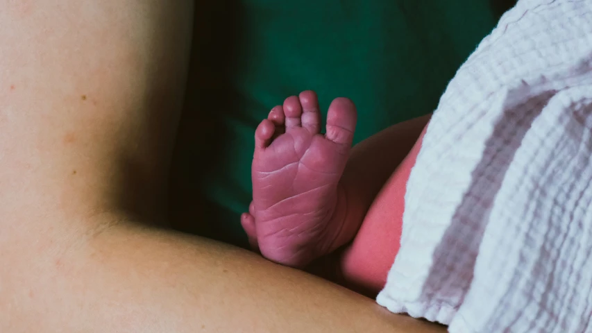 a baby's foot is being held up by a person