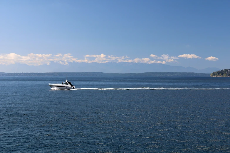 a boat moving through the ocean, while the sky is clear