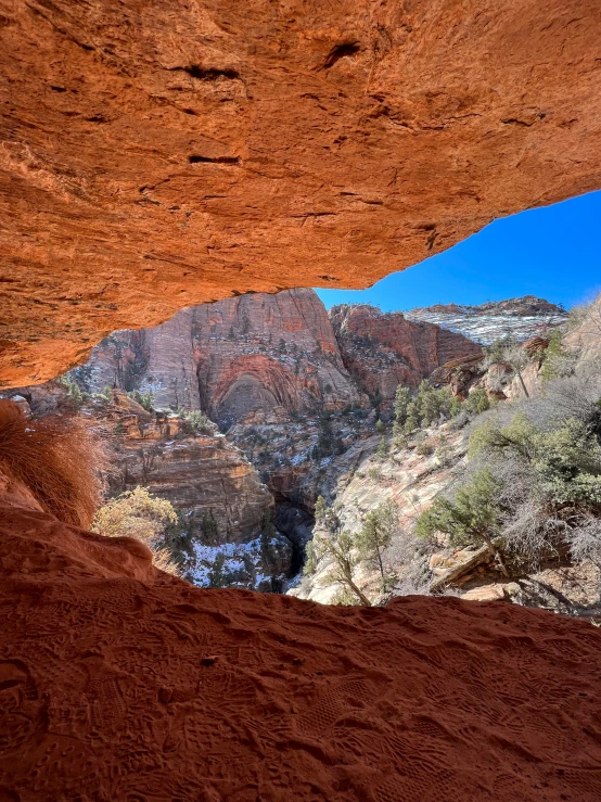 a mountain covered in trees next to a red cliff