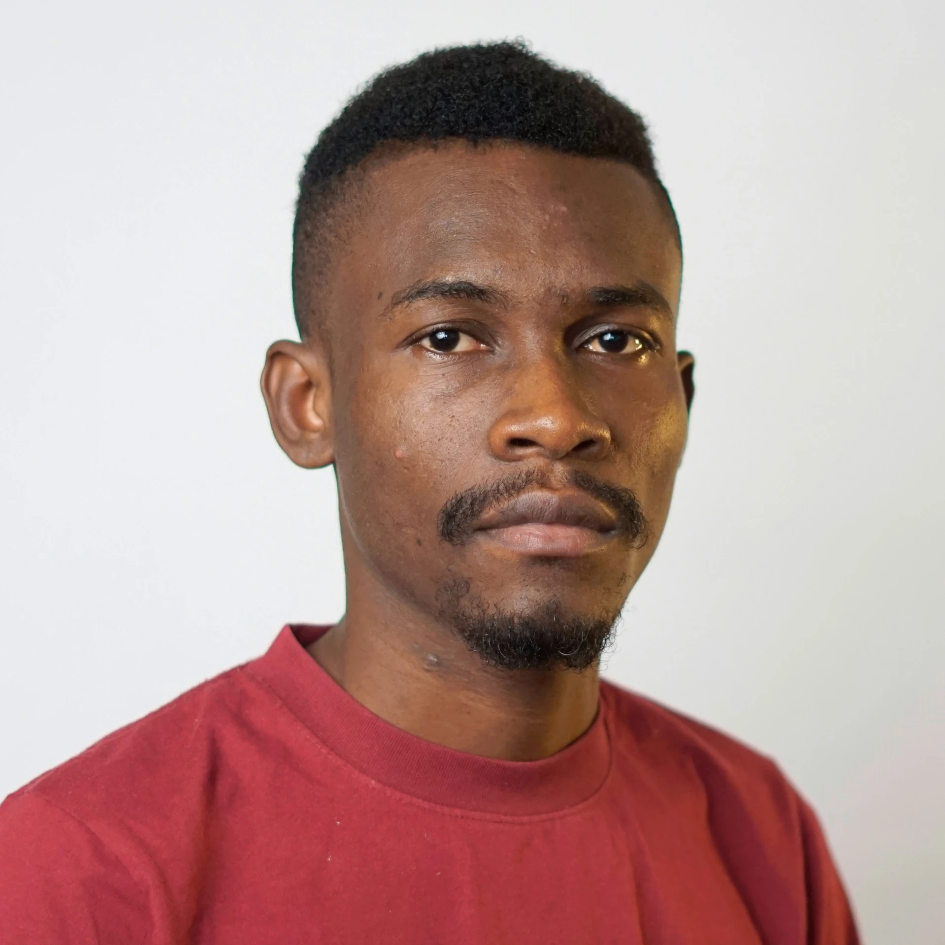 a man with a mustache standing against a white background