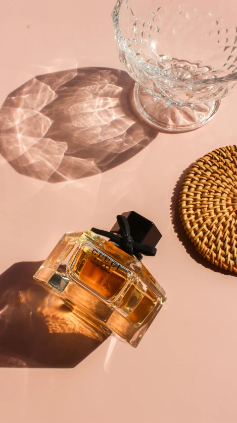 a bottle of eaure de toilette next to a plate with a straw hat