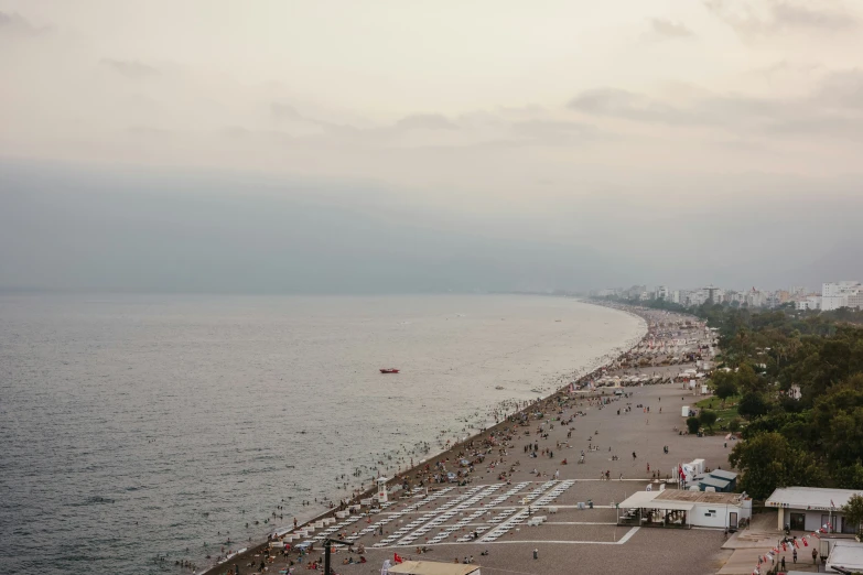 the beach is crowded with people and boats