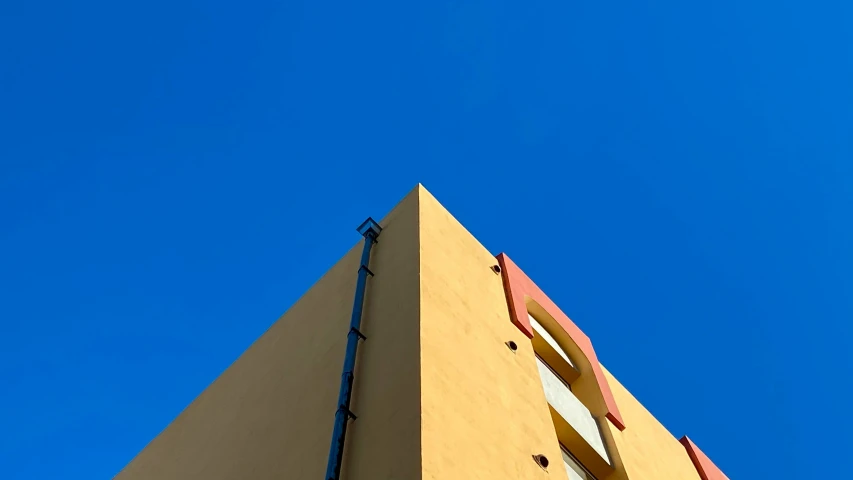 a yellow building with blue skies in the background