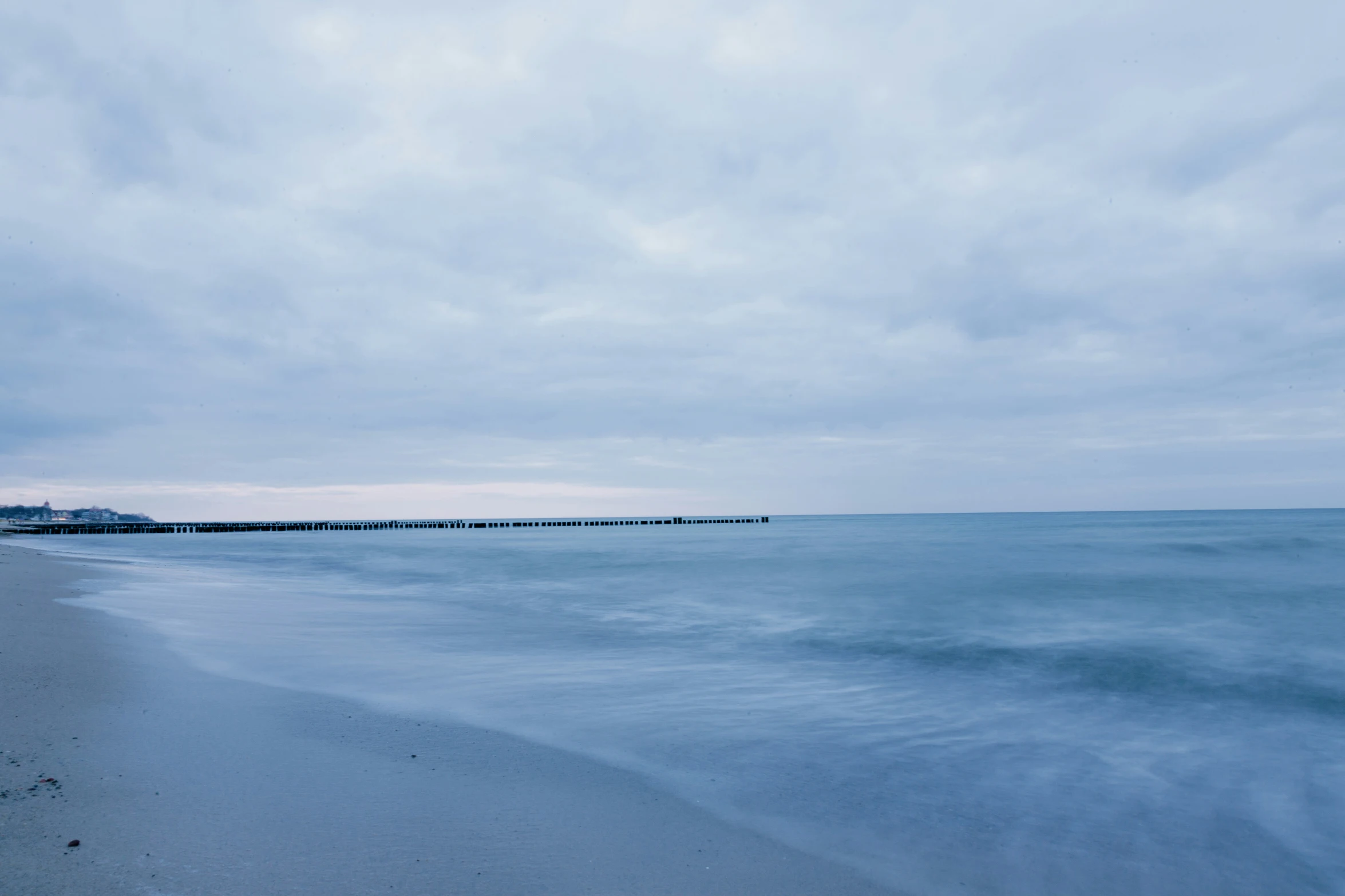 a very pretty beach in the middle of a cloudy sky