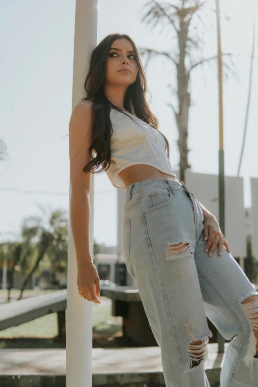 a girl standing next to a pole posing for a picture