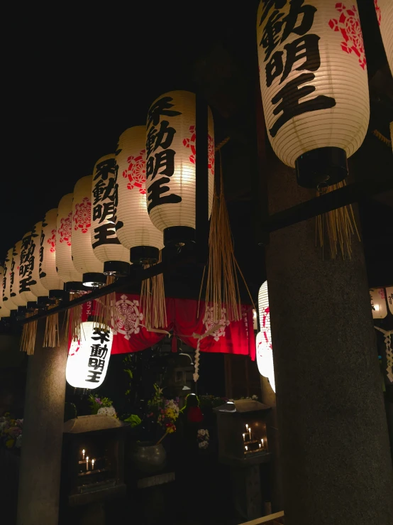 there are numerous asian lanterns hung outside a temple