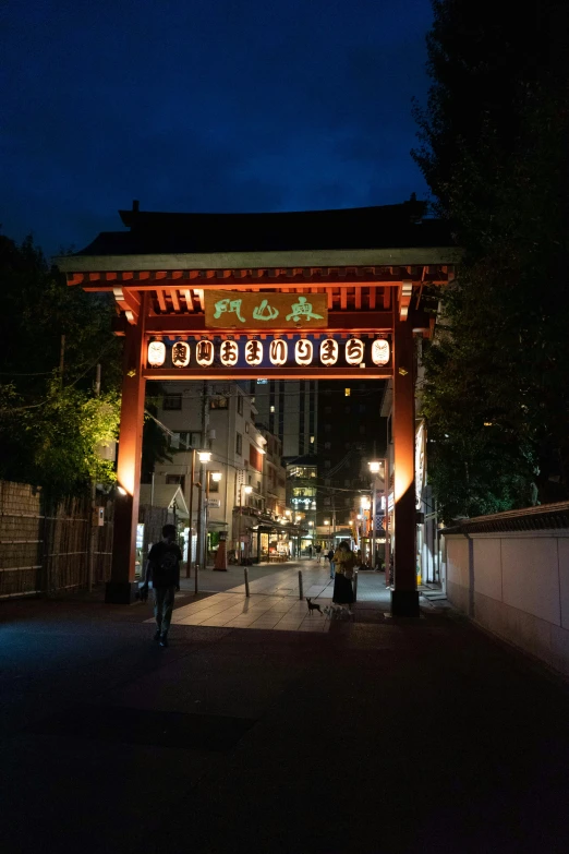an outdoor oriental gate at night with the lights on