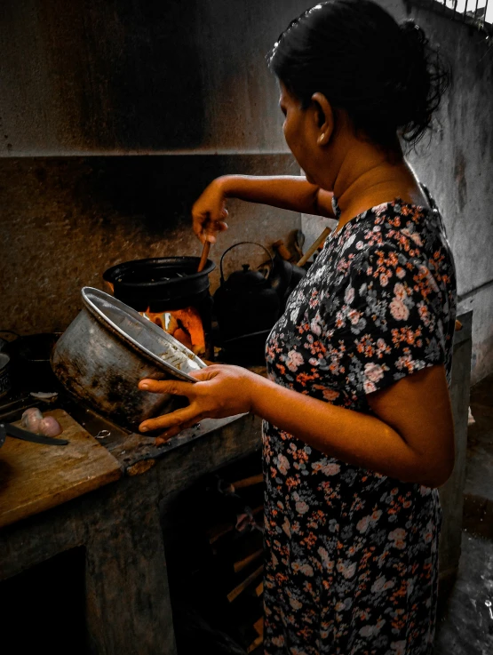 a woman cooking food in a pot on a stove