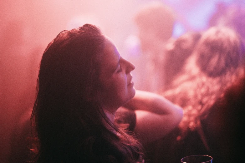 a woman is sitting in front of a large smoke stack