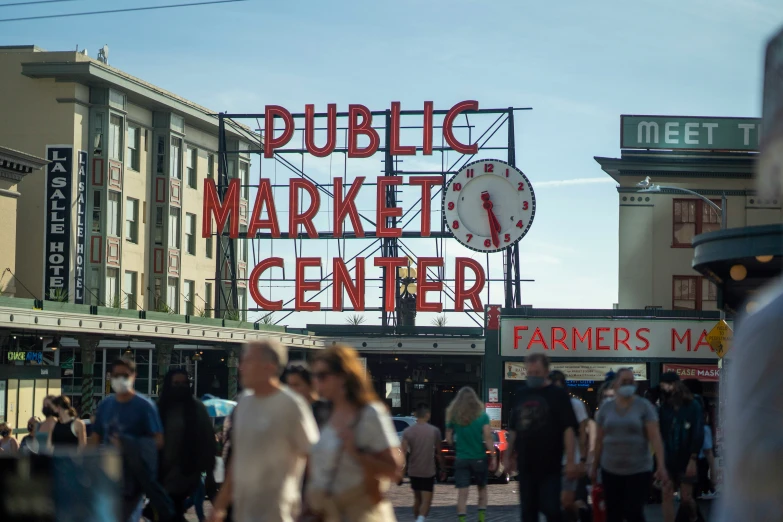 a market center sign and crowd of people walking about