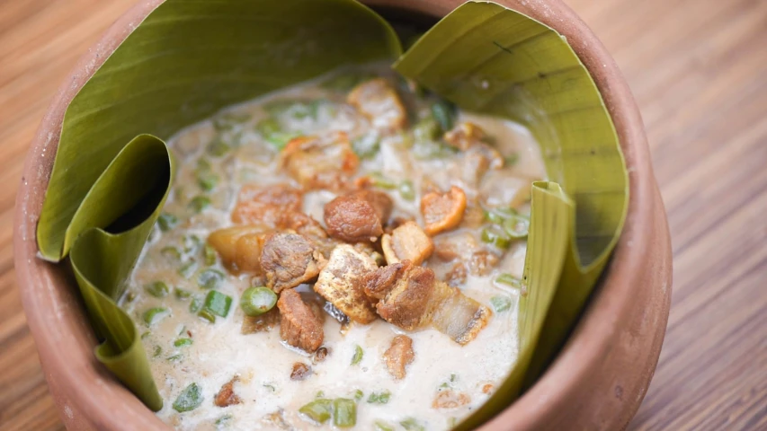 a bowl of oatmeal and peanuts in a leaf - shaped dish