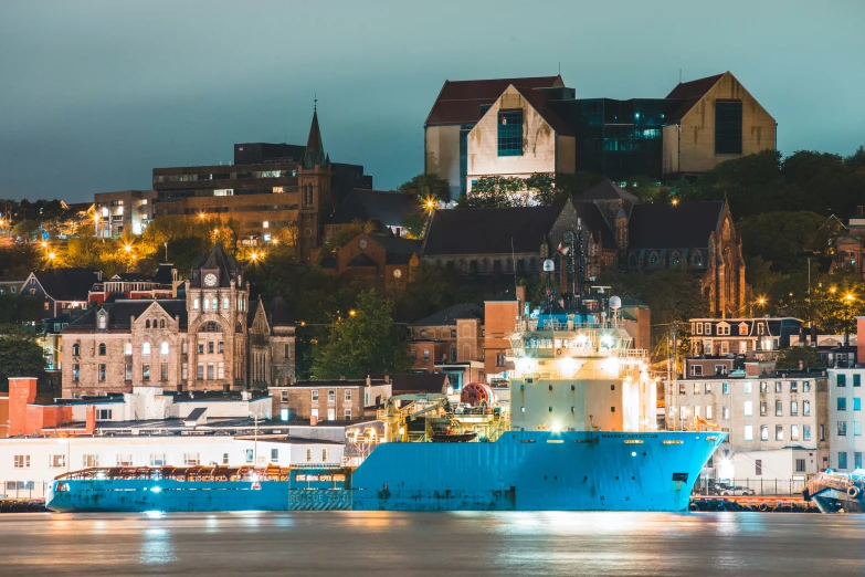 a large blue boat docked by some buildings