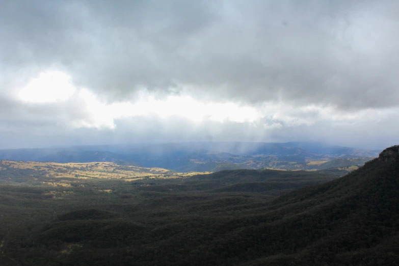 a valley is seen surrounded by dark hills