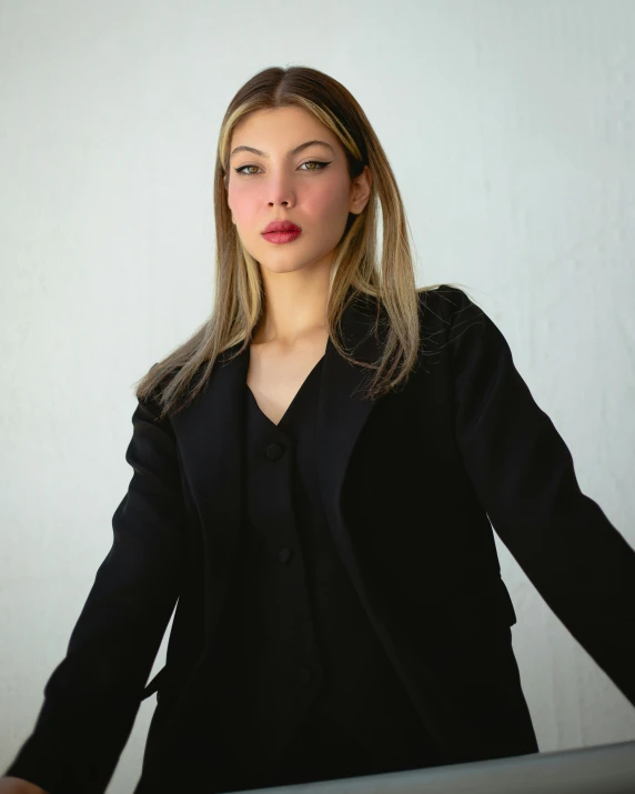 woman in a dark black suit poses for a picture