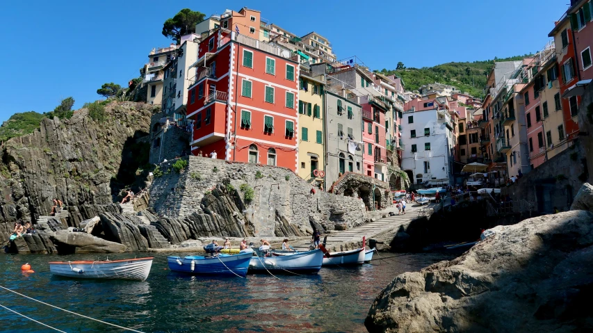 several boats floating in the water next to a row of buildings