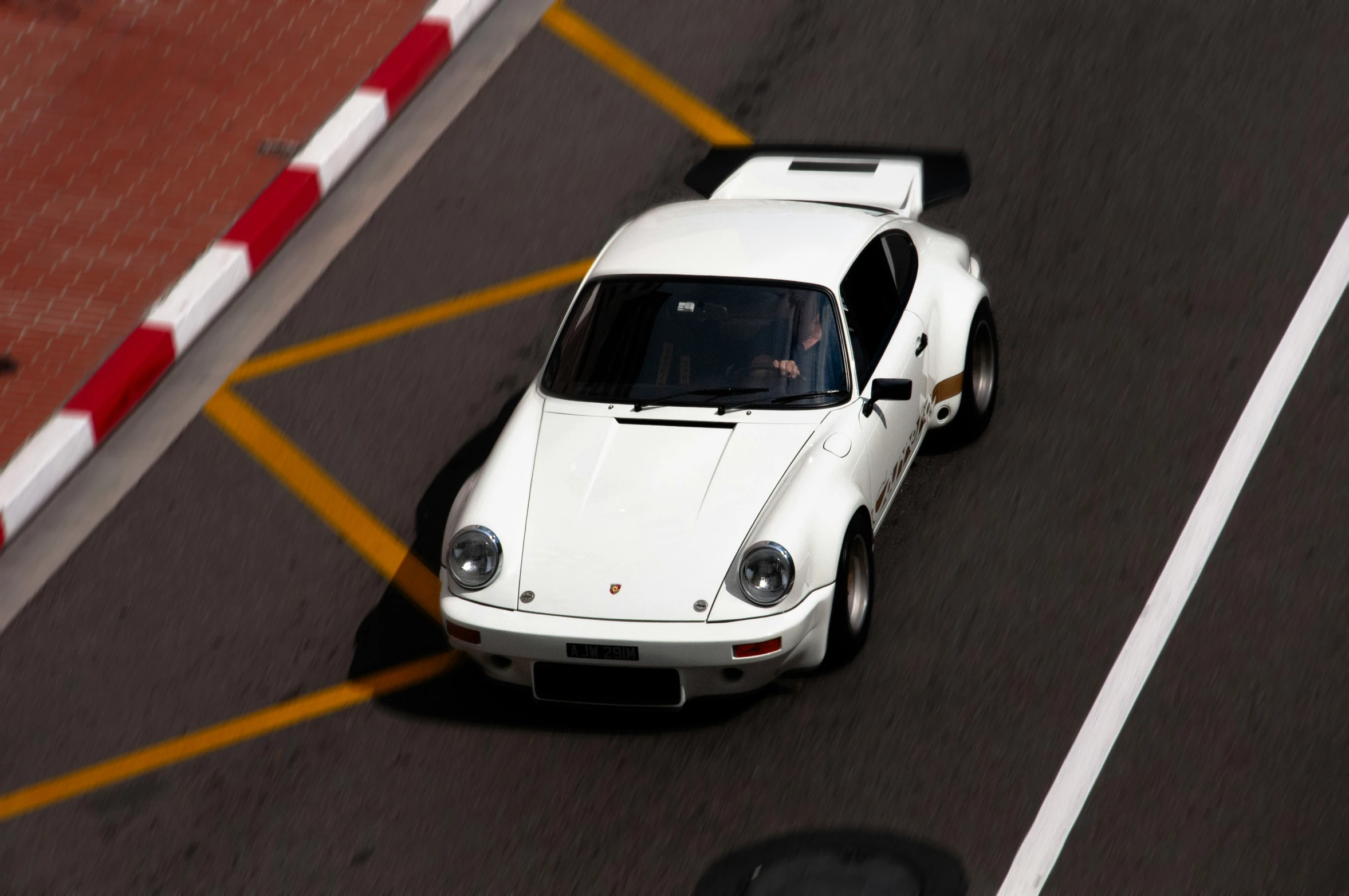 the old fashioned white sports car is driving down the road