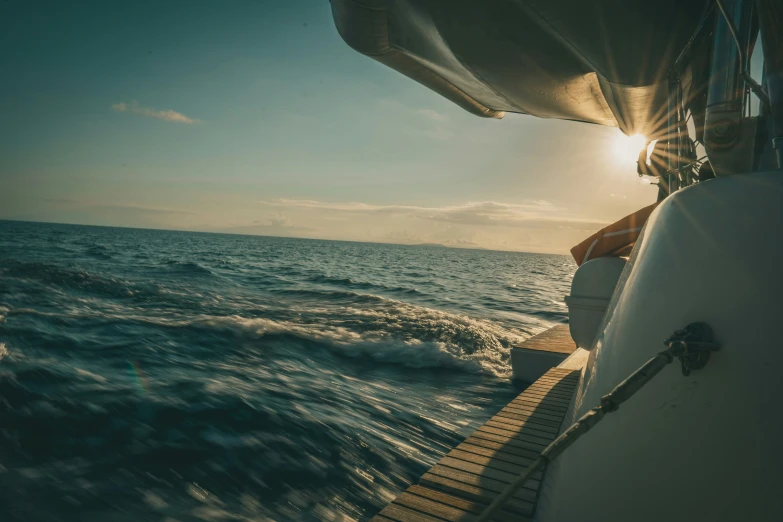 the sun is shining over the water on a boat