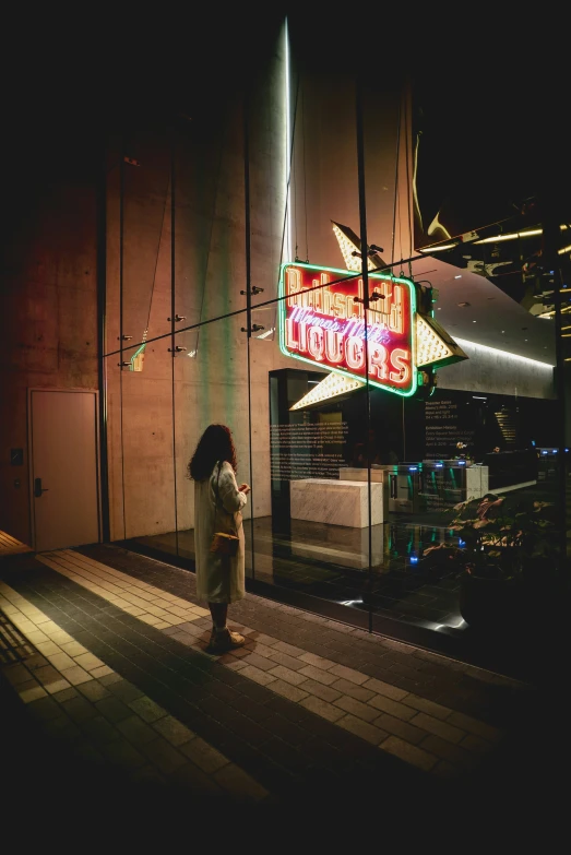 a woman is on the sidewalk in front of a large sign