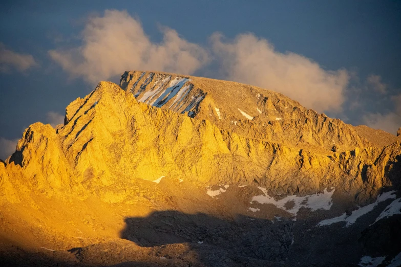 a snowy mountain, with white capped clouds on it