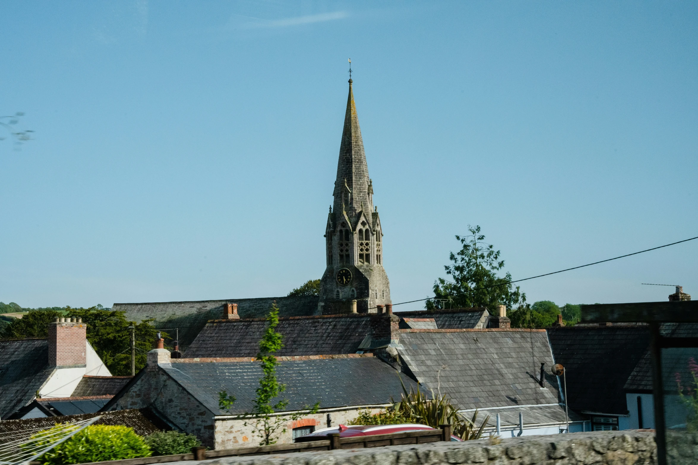 there is a very tall church tower near houses