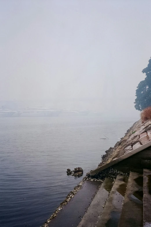 a lone boat sailing along side a stone pier