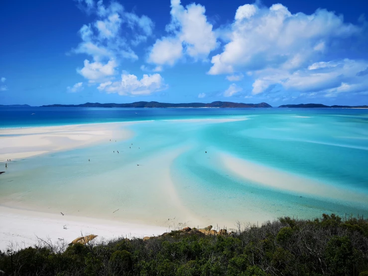 an empty white sandy beach with blue water