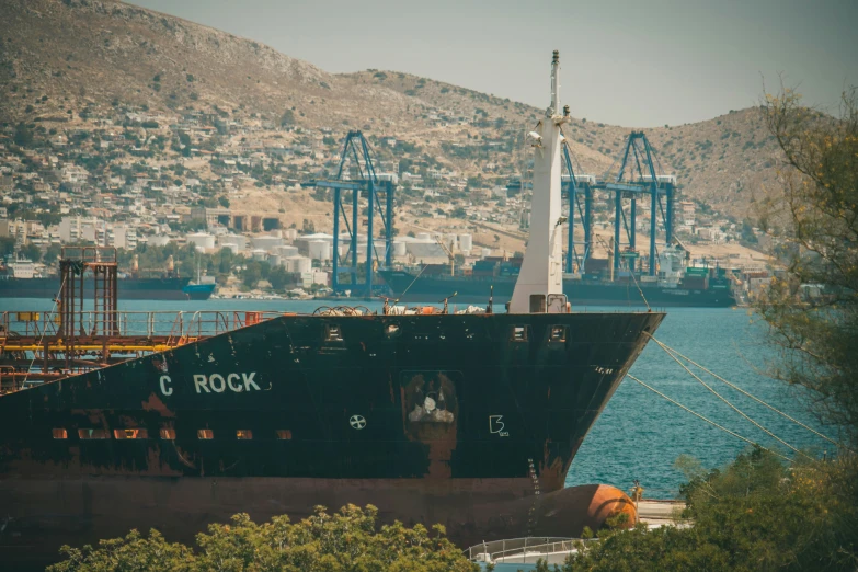 a large boat is anchored at the dock with some cranes