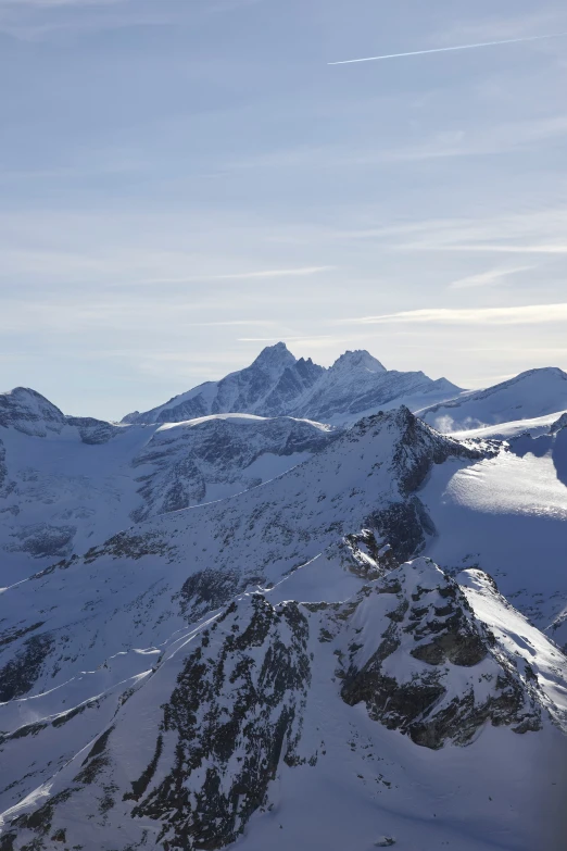 a mountain is covered in snow during a sunny day