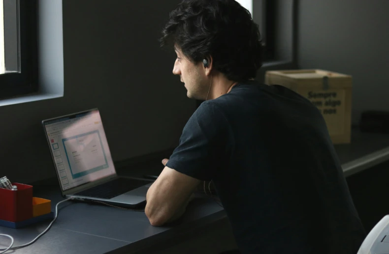 a man on his computer looking out the window