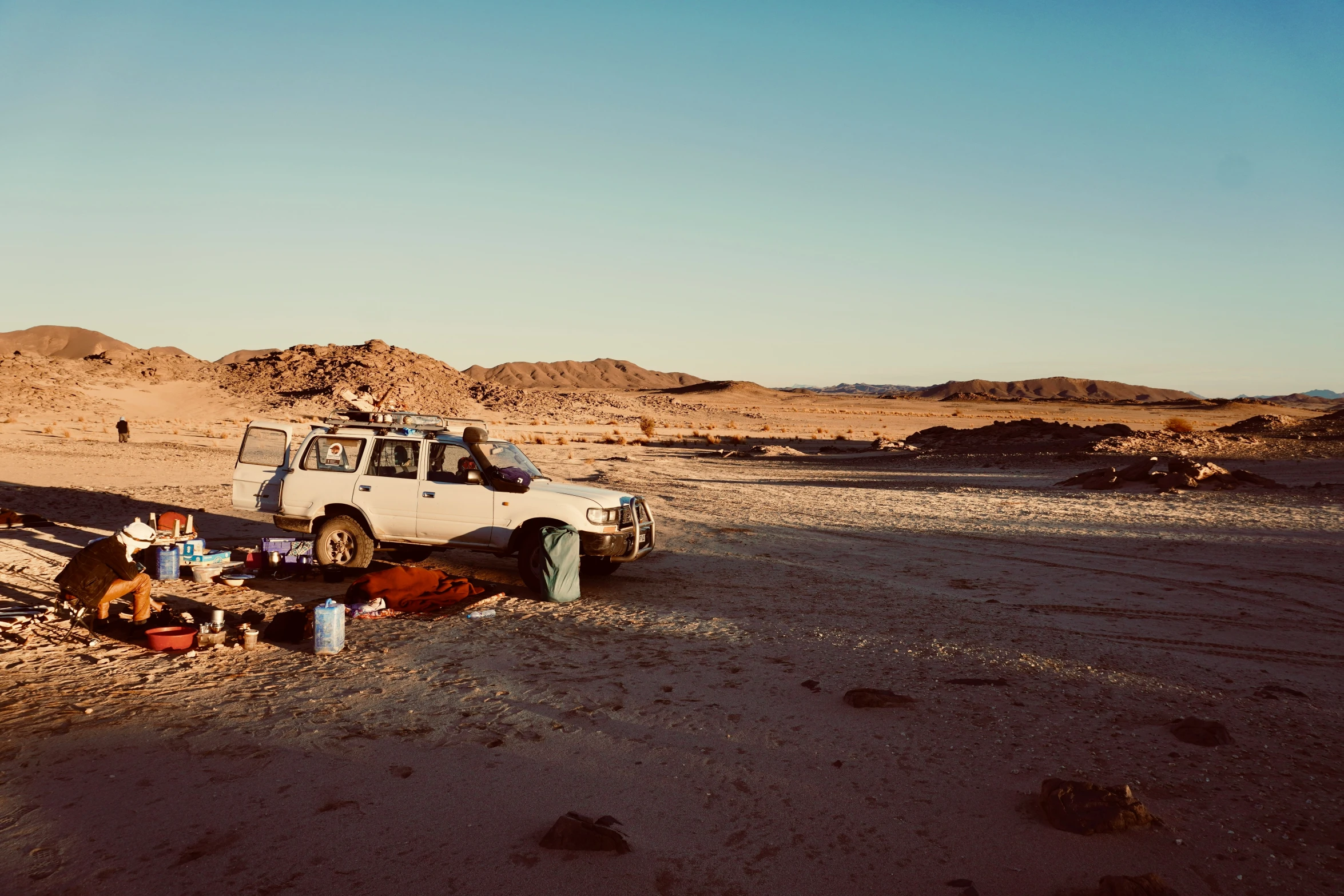 desert setting with various equipment arranged near vehicle