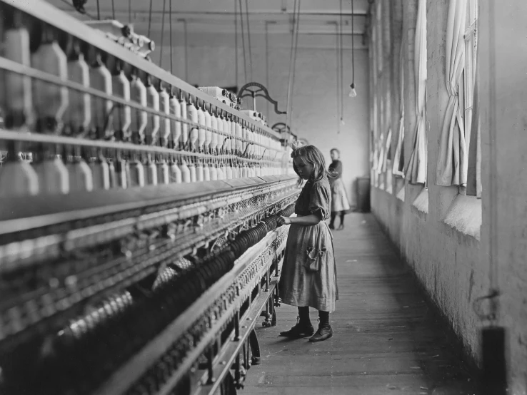 a woman stands next to rows of machines